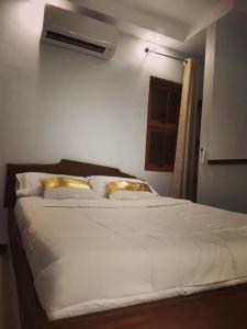 YUMIYAMI FARM AND RESORT的卧室配有带金色枕头的大型白色床