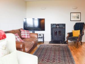 GartmorePuddingstone Cottage的带沙发和电视的客厅