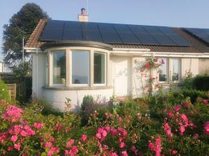 GartmorePuddingstone Cottage的屋顶上设有太阳能电池板的小房子