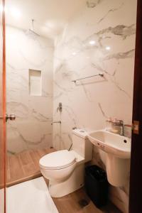 布桑加Josefina's Tourist Inn的白色的浴室设有卫生间和水槽。