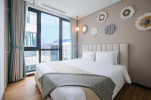 河内Margaery Boutique Apartment & Skyon9 Rooftop Bar的一间卧室设有一张大床和一个大窗户