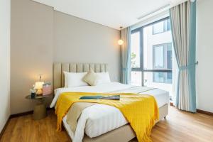 河内Margaery Boutique Apartment & Skyon9 Rooftop Bar的一间卧室配有一张黄色毯子床