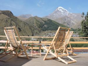 卡兹贝吉Hotel Nestt的山景甲板上配有两把椅子和一张桌子