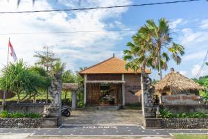 AirsatangWest Break Bali - Medewi的前面有棕榈树的旅馆
