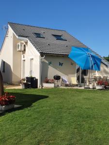 Nébouzatgîte m et m的白色的房子,有蓝色的伞和院子