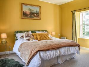 TurriffHayfield - Uk35890的一间卧室设有一张黄色墙壁的大床