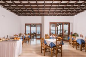 卡拉塔斯Lena Beach Hotel的用餐室设有桌椅和窗户。