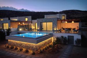 卡尔帕索斯Aros Luxury Villas的一座房子前面设有游泳池