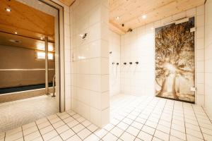 米特尔贝格Ferienhotel Almajur的一间带淋浴的浴室,配有树木壁画