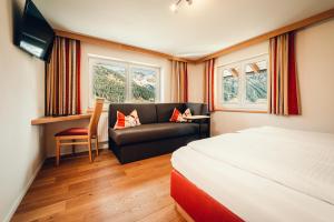 米特尔贝格Ferienhotel Almajur的酒店客房,配有床和沙发