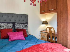霍兹登Ace Lodge的一间卧室配有一张蓝色的床和粉红色枕头