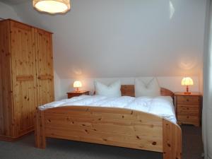 普雷罗Ferienanlage "Haus hinter den Dünen" Prerow的一间卧室配有一张带两盏灯的大木床。