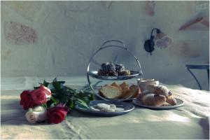 滨海波利尼亚诺拉萨雷拉旅馆的一张桌子,桌子上放着两盘食物,桌子上放着玫瑰