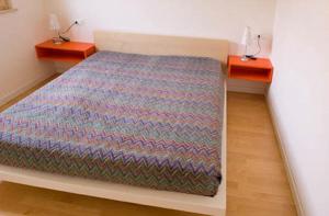 格拉多Residence Mirage的一间卧室配有一张床、两个床头柜和两张桌子