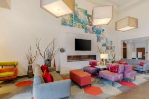 拉夫兰Comfort Suites Loveland的客厅配有色彩缤纷的家具和壁炉