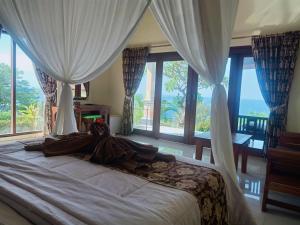 艾湄湾巴厘岛布瓦纳别墅的女人躺在卧室的床上,卧室里设有窗户
