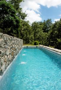 坎德莱达Casa Los Bancales的一座拥有石墙和蓝色海水的游泳池