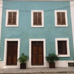 莫桑比克岛Casa Fabula的蓝色的建筑,设有两扇门和两扇窗户