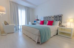 得土安Al Mandari Hôtel Tétouan的白色卧室配有一张带红色枕头的大床