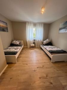 罗登巴赫Linden Monteur Apartment的客房设有两张床,铺有木地板。