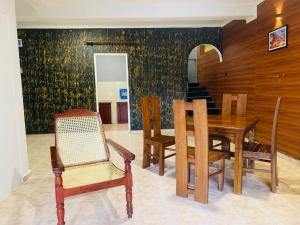 康提Sadhara River View Lodge的一间带木桌和椅子的用餐室
