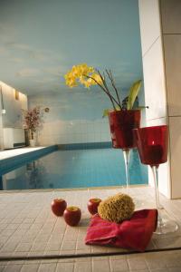 蒂罗尔-泽费尔德Haus Wandl的浴室设有游泳池,提供西红柿和两杯酒杯