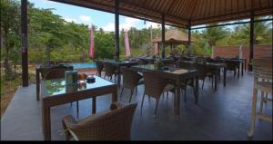 珀尼达岛宾塔格度假酒店的一间带桌椅的餐厅和一个游泳池