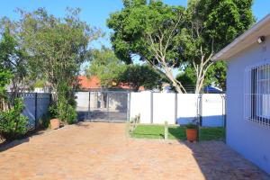 开普敦Lalibela gust house 2的庭院设有白色的围栏和长凳