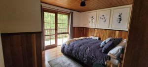 阿波罗湾Tall Trees Eco Retreat的一间卧室设有一张床和一个大窗户