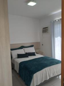 布卢梅瑙Apartamento ao lado da Vila Germânica的一间卧室配有一张带蓝色毯子的大床