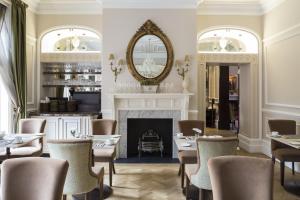 伦敦圣保罗酒店的一间带壁炉和桌椅的用餐室