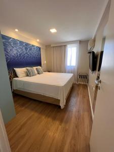 福塔莱萨Top Flat Fortaleza的一间卧室配有一张蓝色墙壁的床