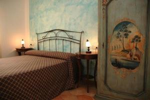 因佩里亚Il tempo di Zia Palmira - AGRITURISMO IL RISVEGLIO的卧室配有一张床,墙上挂有绘画作品