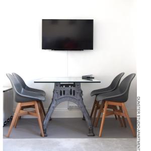 邓斯特Dunster Studio Apartment的一张桌子、两把椅子和一台电视机