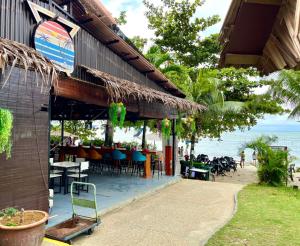 丹绒武雅Seaview Deluxe@Rainbow Paradise Tg Bungah 4-6pax的海滩上的餐厅,配有桌椅