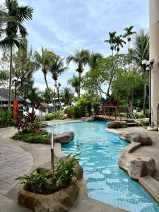 丹绒武雅Seaview Deluxe@Rainbow Paradise Tg Bungah 4-6pax的棕榈树度假村内的游泳池