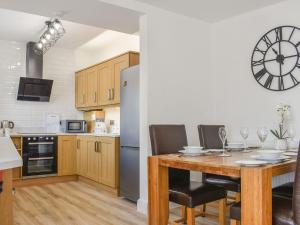 格洛索普Derwent Apartment的厨房配有桌椅和冰箱。