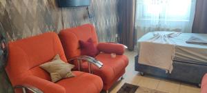 伊斯坦布尔Midtown Hotel Apartments 404 ( 2+1)的客厅配有橙色椅子和床