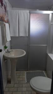 欧鲁普雷图Suíte Aconchegante em Hospedaria no Centro的浴室配有盥洗盆、淋浴和卫生间