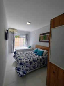 鲍巴鲍巴海滩酒店的一间卧室配有一张带蓝色枕头的床