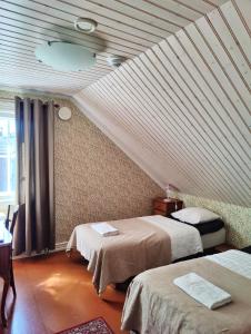 瑙沃兰特娜酒店&咖啡馆的客房设有两张床和天花板。