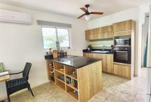 拉贡Apartment Lagoon Ocean Resort的厨房配有木制橱柜和黑色台面