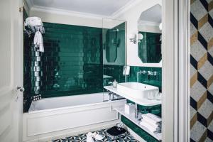 巴黎皮嘉尔大酒店的带浴缸、水槽和镜子的浴室