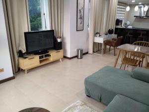 古晋Santubong Suites Sejinjang的客厅配有平面电视和沙发。