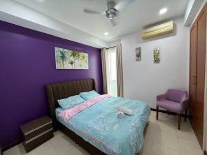古晋Santubong Suites Sejinjang的紫色卧室,配有一张床和紫色的墙壁