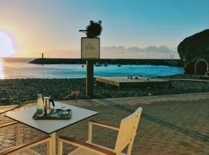 圣尼科拉斯村De Sebastian 1 - estudio frente al mar的海滩上的一张桌子和一把椅子,享有日落美景