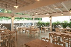 Noventa VicentinaHotel da Romagnolo的餐厅设有木桌、椅子和窗户。
