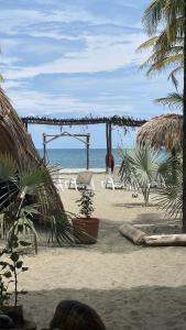 圣贝尔纳多德尔比恩托älanacasadeplaya的海滩上设有椅子和凉亭,还有大海