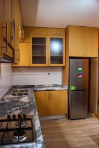 普拉亚Helton´s Residence的厨房配有木制橱柜和不锈钢冰箱。