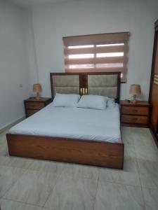杰拉什Furnished apartment for rent in jarash شقة مفروشة للإيجار في جرش的一间卧室配有一张带2个床头柜的大床